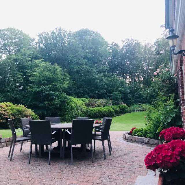 Garden terrace with dining table at Letbæk Mølle